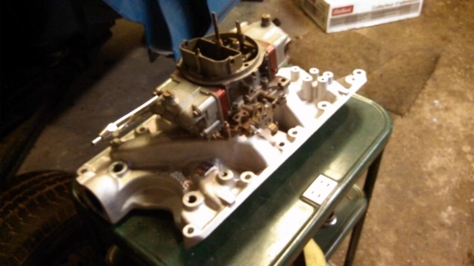 Engine intake manifold and carburetor assembly on a table