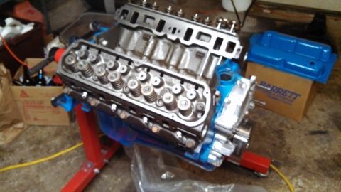 1977 Ford F-150 - Engine block assembly on a stand, with a box labeled 'BARRETT' in the background.