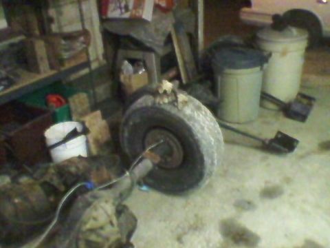 1977 Ford F-150 - A spare tire and differential are visible on the floor of a workshop, with various items in the background.