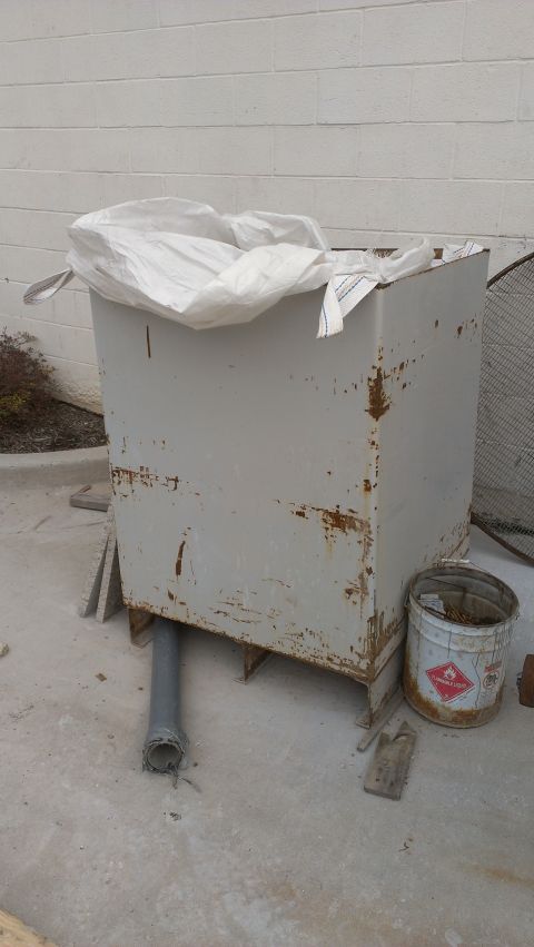 1995 Ford Bronco - A large, weathered metal container sits outdoors, partially covered by a white tarp, next to a hazardous materials bucket.