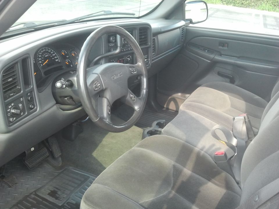 Gray interior of a 2004 GMC Sierra 1500 with cloth seats and dashboard