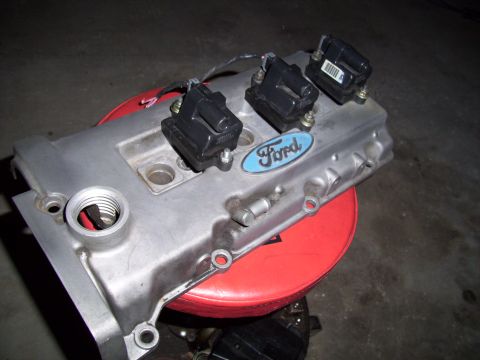 1995 Ford Probe - A Ford valve cover with ignition coils is shown, with a blue oval Ford logo visible.