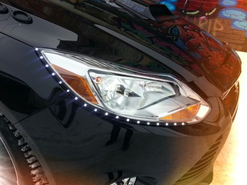 2012 Ford Focus - A black car's front end is shown with custom LED accent lighting and a visible horsepower rating on the hood.