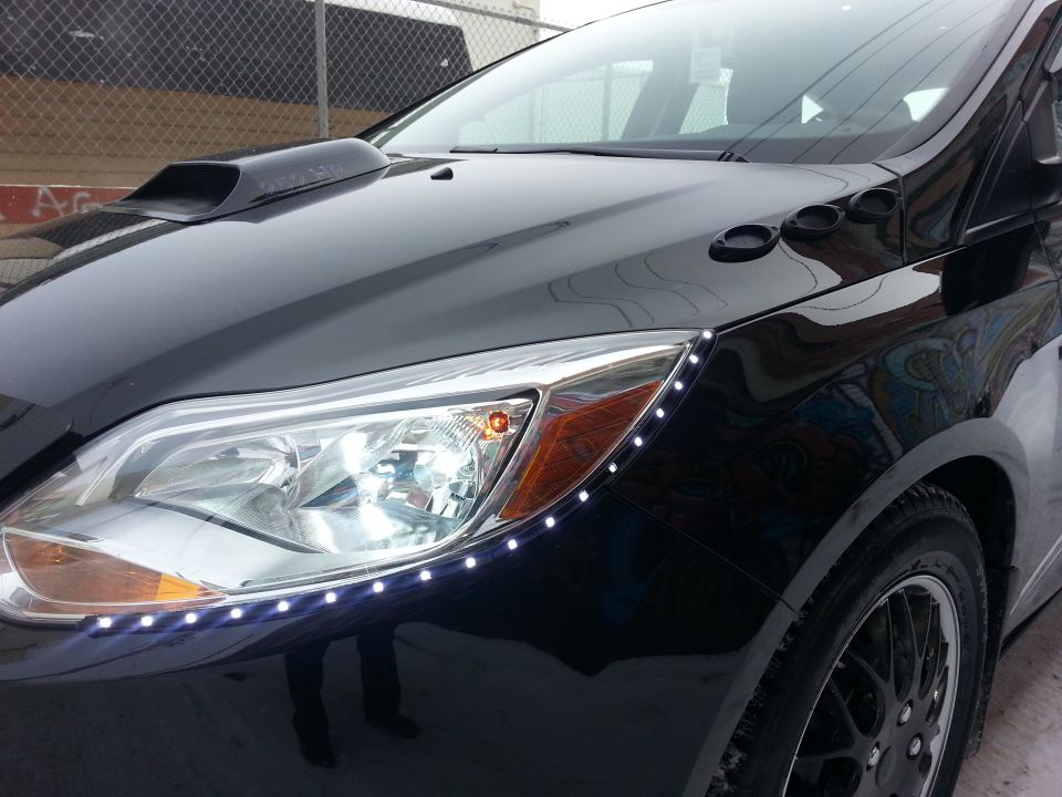 Black car's front fender with LED strip lights and hood scoop