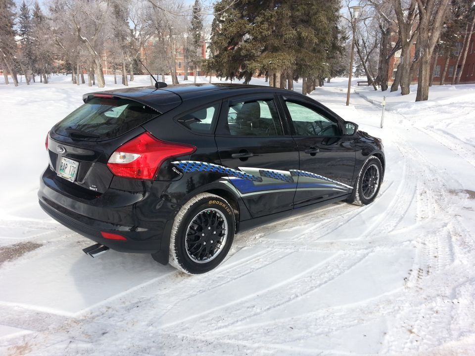 Black 2012 Ford Focus hatchback with blue graphics on the side, parked in the snow