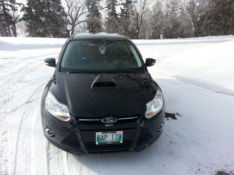2012 Ford Focus - A black 2012 Ford Focus is shown from the front in a snowy environment.