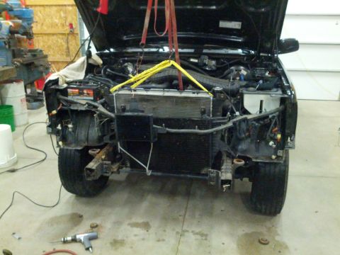 1995 Ford Bronco - Front end of a 1995 Ford Bronco undergoing repairs, with the radiator out and hood raised.