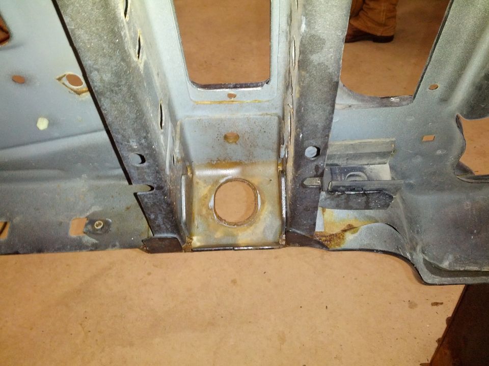 1995 Ford Bronco frame section with rust and holes, viewed from below