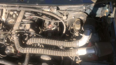 1995 Ford Bronco - Engine bay with aftermarket air intake system installed.