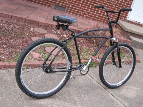 1994 Ford Bronco - Custom cruiser bicycle with a black frame, wide handlebars, and knobby tires.