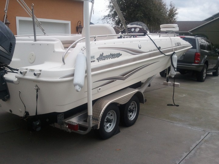 White Hurricane boat on trailer with a dark SUV behind it