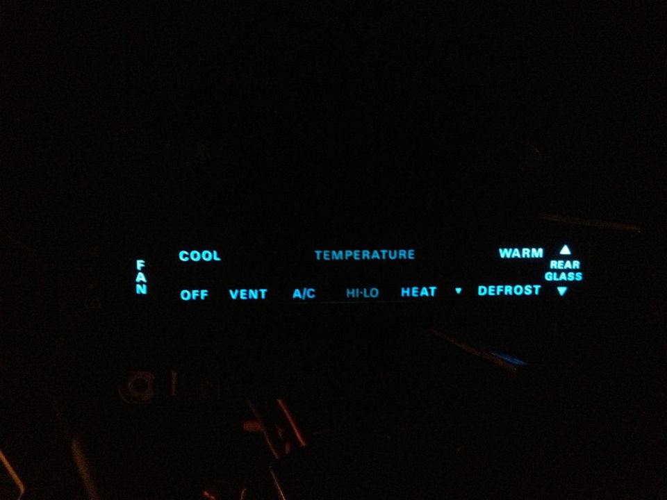 Climate control panel with glowing blue text for fan, cool, temperature, warm, and defrost