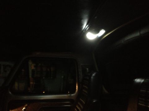 1979 Ford Bronco - The interior of a vehicle is dimly lit, showing the headliner and a side window.