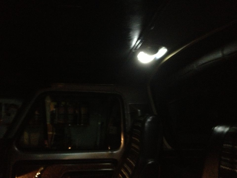 Interior shot of a vehicle, looking towards the ceiling light and side window