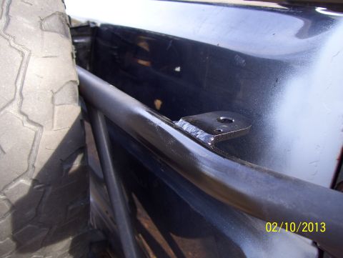 1990 Ford Bronco - Close-up of a spare tire and a roll bar mounted inside a vehicle.