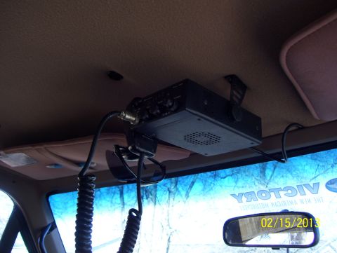 1990 Ford Bronco - A CB radio is mounted to the interior ceiling of a vehicle, with sunglasses hanging nearby.