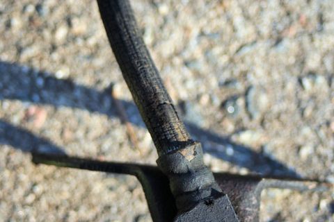1976 Ford Ranchero - Close-up of a deteriorated brake hose, showing significant wear and cracking on its protective outer layer.