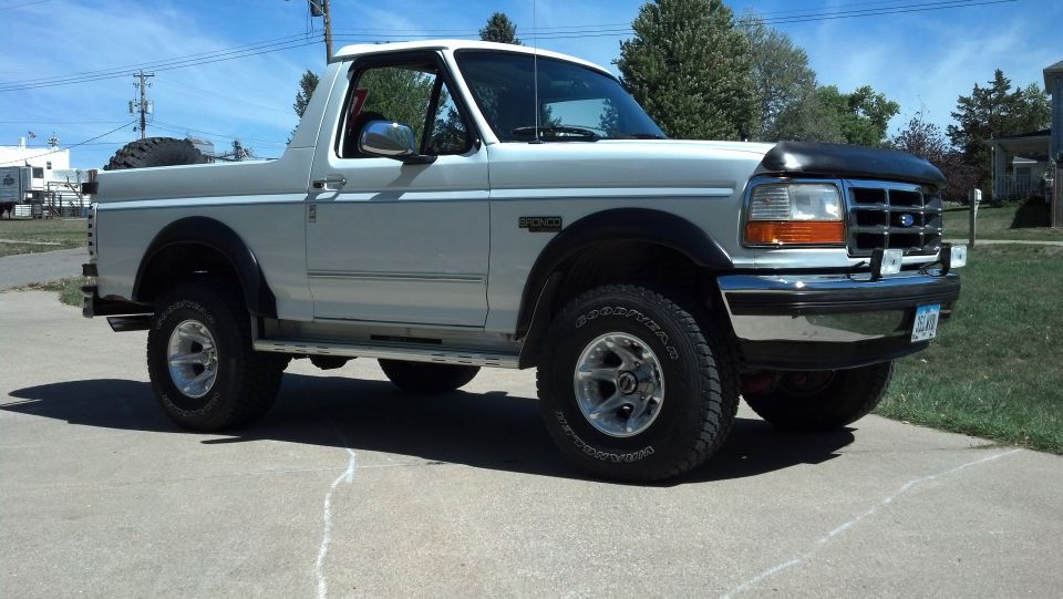 Silver 1995 Ford Bronco parked on a driveway, showing the front and side