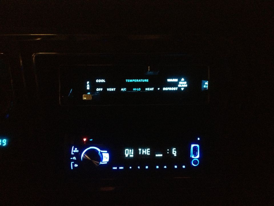 Dashboard climate controls and radio display illuminated at night