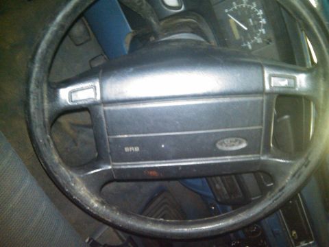 1993 Ford Bronco - The interior of a 1993 Ford Bronco is visible, focusing on the steering wheel and dashboard area.