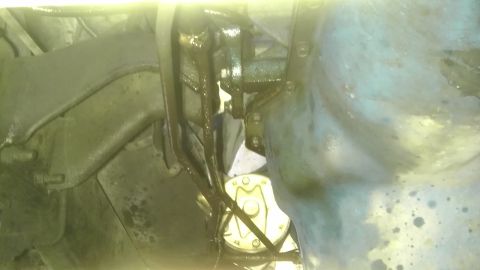 1982 Jeep Wagoneer - The underside of a vehicle shows greasy components and a yellow circular part.