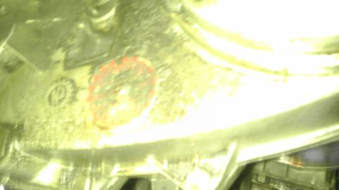 1982 Jeep Wagoneer - A close-up view of a vehicle component, showing some stamped markings and a red circular label.