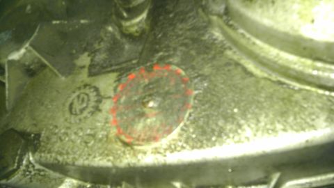 1982 Jeep Wagoneer - Close-up of a greasy engine component with a red-ringed bolt and stamped markings.