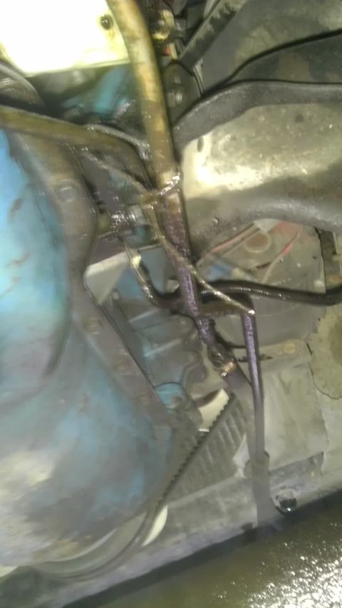 1982 Jeep Wagoneer - Visible oil leak in the engine bay from a hose onto various components.