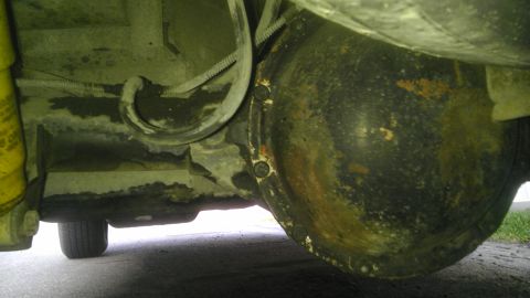 1982 Jeep Wagoneer - Underside view of a vehicle's rear differential and suspension components, showing signs of wear and rust.