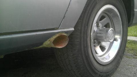 1982 Jeep Wagoneer - The rear wheel and exhaust pipe of a vehicle are shown in this close-up shot.