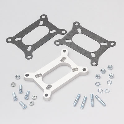 1982 Jeep Wagoneer - A set of carburetor spacer and gaskets with associated hardware is displayed against a plain background.