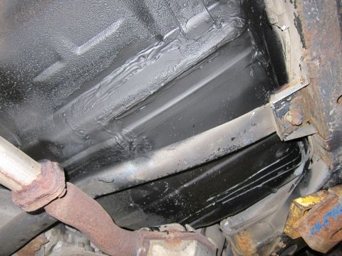 1991 Ford LTD Crown Victoria - Close-up of the vehicle's underbody, revealing structural components and the exhaust system.