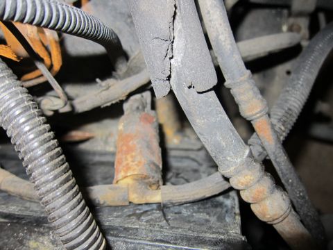 1991 Ford LTD Crown Victoria - Detail of engine compartment showing worn hoses and corroded parts.