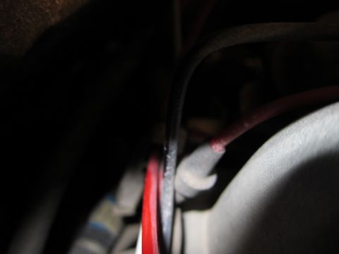 1991 Ford LTD Crown Victoria - A close-up view of a vehicle's electrical wiring, showing red and black cables connected.