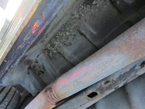 1991 Ford LTD Crown Victoria - Close-up view of the undercarriage of a vehicle, highlighting the exhaust system and frame components.
