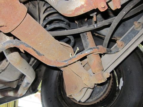 1991 Ford LTD Crown Victoria - Undercarriage view showing the rear suspension system and a tire, with visible signs of rust.