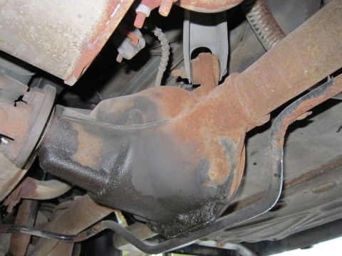 1991 Ford LTD Crown Victoria - The rear differential shows significant rust and oil leakage, indicating potential maintenance issues.