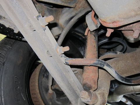 1991 Ford LTD Crown Victoria - Close-up view of the rear suspension system, showing the shock absorber, coil spring, and control arms.