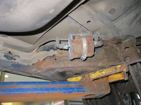1991 Ford LTD Crown Victoria - The fuel filter and surrounding frame components on this vehicle show significant rust.