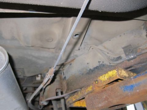 1991 Ford LTD Crown Victoria - The underside of a vehicle shows significant rust and a brake cable, with no clear year identification.