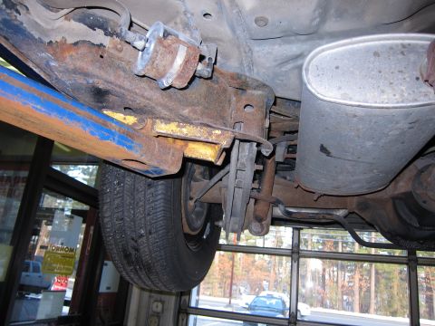 1991 Ford LTD Crown Victoria - The underside of a vehicle shows significant rust on the frame and suspension components, with a fuel filter visible.