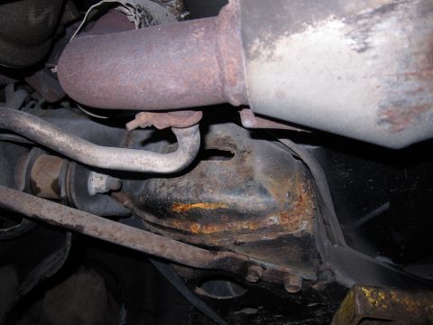 1991 Ford LTD Crown Victoria - Close-up view of the underbody, showing significant rust on the exhaust system and differential.