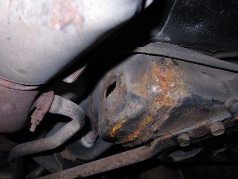 1991 Ford LTD Crown Victoria - Close-up view of heavily rusted undercarriage components, likely from an older vehicle.