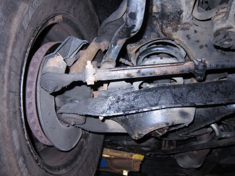 1991 Ford LTD Crown Victoria - Close-up view of the front suspension components and tire, showing the brake rotor and steering linkage.