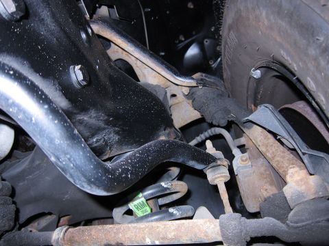 1991 Ford LTD Crown Victoria - Front suspension components including control arm and spring, with a tire in the background.