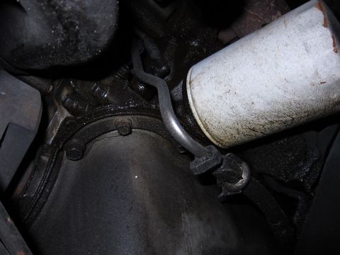 1991 Ford LTD Crown Victoria - Underside view of an engine component, likely an oil filter and oil pan, with visible oil stains.