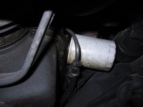 1991 Ford LTD Crown Victoria - Close-up view of an oil filter and surrounding engine parts, showing mechanical components.