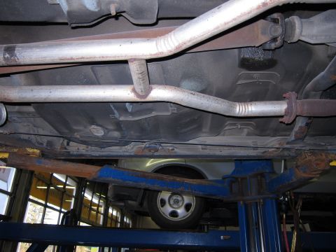 1991 Ford LTD Crown Victoria - The underside of a vehicle is shown while it is raised on a car lift for service.