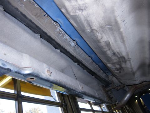 1991 Ford LTD Crown Victoria - Close-up of the undercarriage, revealing the frame and suspension components with signs of wear and rust.