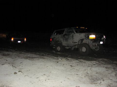1995 Ford Bronco - Two vehicles are seen off-road at night, one is a muddy 1995 Ford Bronco.